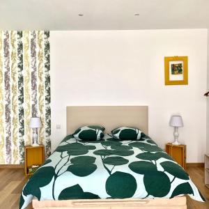 圣埃尔斯Atelier des Vidaux的一间卧室配有一张带绿色和白色棉被的床