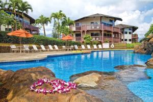 普林斯维尔Club Wyndham Ka Eo Kai的度假村的游泳池,配有椅子和遮阳伞