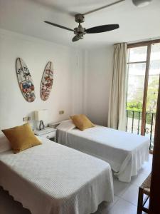 波连萨港Port Pollensa Pins Apartment sea view的一间卧室配有两张床和吊扇