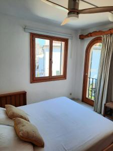 波连萨港Port Pollensa Pins Apartment sea view的一间卧室设有一张大床和两个窗户