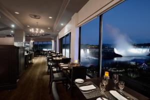 尼亚加拉瀑布Crowne Plaza Hotel-Niagara Falls/Falls View, an IHG Hotel的餐厅设有桌椅和大窗户。