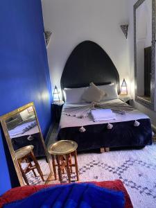 马拉喀什娜雅庭院旅馆的一间卧室配有一张床、镜子和椅子