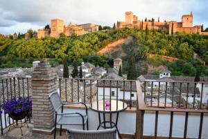 格拉纳达Apartamentos Alhambra的阳台配有桌椅和城堡。