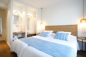洛尼亚德圣佩德尔Petit H Rocamar - Adults Only的一间卧室配有一张带蓝白色枕头的大床