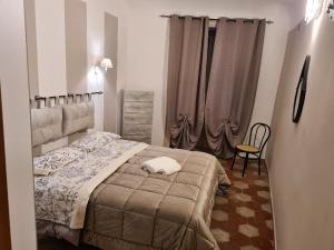 巴勒莫Agorà Sant’anna Apartment的一间卧室配有床、椅子和窗帘
