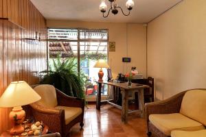 危地马拉Hostal Donde Regina的客厅配有椅子、桌子和窗户