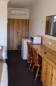 Leeton里弗赖纳汽车旅馆的客房配有桌子、微波炉和冰箱。