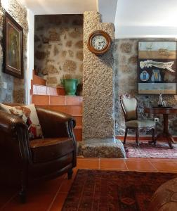 戈韦阿Anibals Boutique Lodging - Serra da Estrela的客厅配有沙发和墙上的时钟