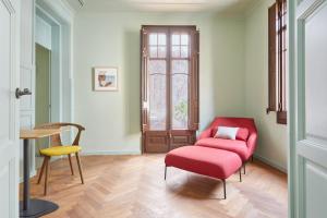 巴塞罗那Le Palacete powered by Sonder的客厅配有红色椅子和桌子