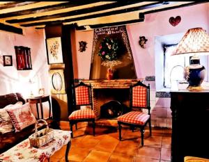 ValeriaRoom in Lodge - Romantic getaway to Cuenca The fifth的客厅设有壁炉、两把椅子和一张桌子