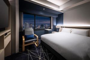 神户remm plus Kobe Sannomiya的酒店的客房 - 带一张床、椅子和窗户