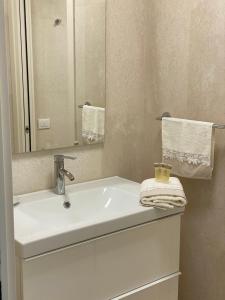 的里雅斯特Panorama Apartment的浴室设有白色水槽和镜子