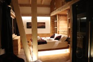 科尔蒂纳丹佩佐Hotel Ciasa Lorenzi的木制客房内的一间卧室,配有一张床