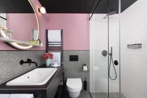 布达佩斯Alice Hotel的粉红色的浴室设有水槽和淋浴