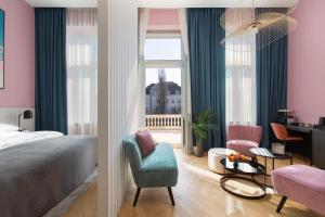 布达佩斯Alice Hotel的卧室配有床、椅子和窗户。