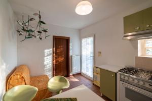 多尔切阿夸Casetta Maduneta immersa in un oliveto的厨房配有绿色橱柜和桌椅