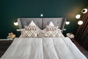 特里滕海姆Moselweingut & Gästehaus Hubertushof的一间卧室配有带白色床单和枕头的床。