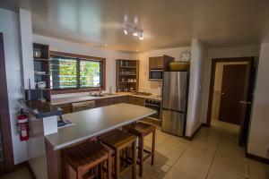 拉罗汤加朗德屋别墅酒店的厨房配有桌子和冰箱