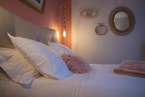 阿尔比Le Rez de Jardin Albi的一间卧室配有一张带白色枕头和镜子的床