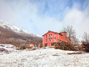 维拉诺瓦Hotel La Casa del Río的雪覆盖的山顶上的红房子