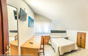 桑亨霍Apartamento Mardevela的一间卧室配有一张床、一张书桌和一面镜子