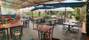 斯培西亚美丽那不勒斯旅馆及意大利比萨饼餐厅的一间带桌椅和遮阳伞的餐厅