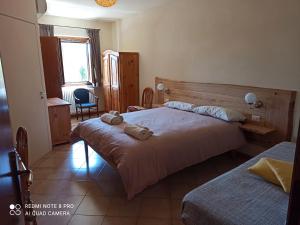 PeveragnoTrattoria della Posta的酒店客房设有两张床和窗户。