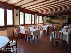 PeveragnoTrattoria della Posta的餐厅设有白色的桌椅和窗户。