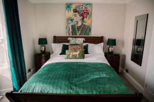 锡豪西斯Slate Hall的一间卧室配有一张带绿色棉被的床