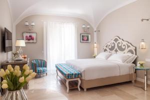 莫诺波利Hotel Don Ferrante的卧室配有白色的床和桌椅