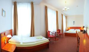 克拉托维中央健康酒店的一间设有两张床和一张桌子及椅子的房间