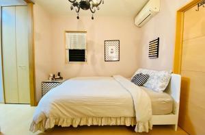 神户Mori de house in Kobe 201的卧室配有白色的床和吊灯。