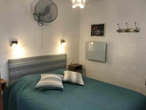 滨海托萨Apartamento Terrassa 1的一间卧室配有一张带两个枕头的床和风扇