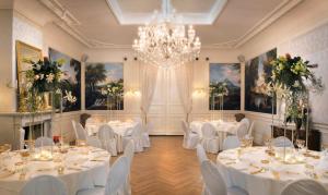 莱顿Boutique Hotel Huys van Leyden的宴会厅配有白色的桌椅和吊灯