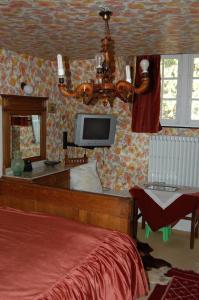 Hatrival莱斯吉奈住宿加早餐旅馆的一间卧室配有一张床、一台电视和吊灯。
