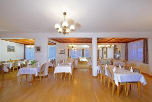 采尔马特阿尔夫贝尔酒店的一间设有白色桌椅的用餐室