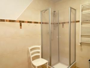 奥斯特巴德·哥伦维拉瑟费施公寓的浴室内带白色椅子的玻璃淋浴间