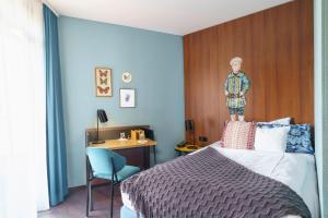 波恩Tante ALMA's Bonner Hotel的一间卧室配有一张带木制床头板的床和一张书桌