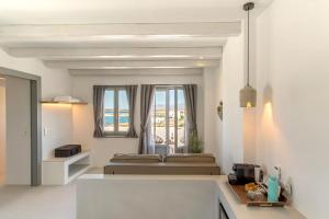 纳乌萨Paros Cape Suites的白色的客房设有床和窗户。