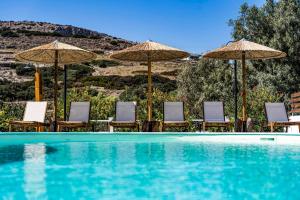 加利萨斯Anassa Cycladic Village的一个带椅子和遮阳伞的游泳池