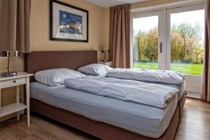 埃尔讷沃德Woonboot Sweltsje的卧室设有一张大床,卧室设有大窗户