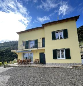 文蒂米利亚Agriturismo Soleada的大型黄色房屋 - 带椅子和阳台