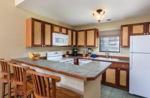 科纳温德姆科纳夏威夷度假酒店的厨房配有木制橱柜和白色冰箱。