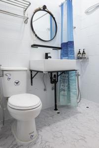 小琉球岛島氮潛水背包客棧 PlayfulDiveClub的一间带卫生间、水槽和镜子的浴室