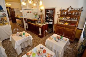 威尼斯帕拉佐欧多尼酒店的一间设有两张桌子的房间,配有白色桌布