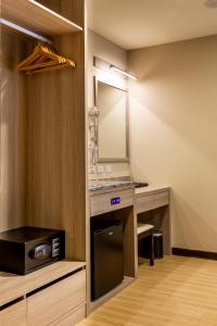 大溪桃园大溪三桥渡假旅店的一间带镜子、水槽和微波炉的浴室