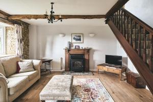 斯多克兰Blackdown Cottage的带沙发和壁炉的客厅