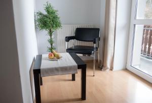 Strass im AttergauApartment Haus Sagerer near Attersee and Mondsee的椅子和桌子,上面放着一碗水果和植物