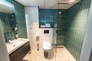 ZaandijkBoutique Hotel Zaan的绿色瓷砖浴室设有卫生间和水槽