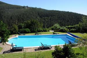 塞洛里库迪巴什图金塔达斯经济酒店的一座位于庭院内的游泳池,山底下